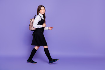 Wall Mural - Full length body size profile side view of nice attractive lovely cheerful cheery wavy-haired pre-teen girl going to school class isolated over bright vivid shine violet background