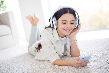 Poster - Portrait of her she nice attractive lovely charming cute cheerful cheery dreamy wavy-haired preteen girl lying on carpet listening track list in light white interior living-room house indoors