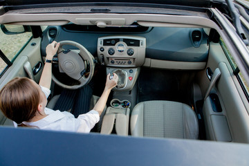 Close up portrait of pleasant looking female with glad positive expression, being satisfied with unforgettable journey by car, sits on driver s seat. People, driving, transport concept