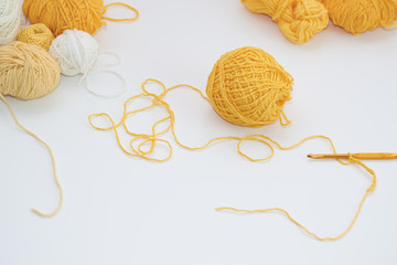  girl knits crochet, on a white background, the process of knitting close-up, yellow ball of thread crochet hook