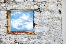 White Old Stone Wall With Blue Sky And Clouds Window. Concept Of Liberation And Freedom.
