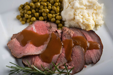 Wall Mural - traditional roast beef served with gravy sauce, peas and mashed potato