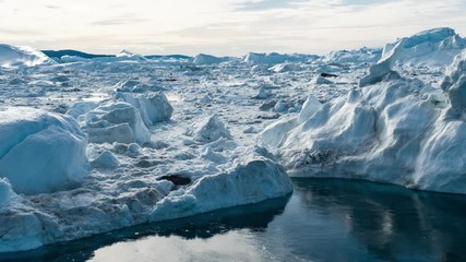 Wall Mural - Iceberg aerial drone video- giant icebergs in Disko Bay on greenland floating in Ilulissat icefjord from melting glacier Sermeq Kujalleq Glacier Affected by Global warming and climate change.