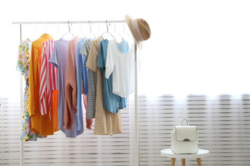 Canvas Print - Women's hip clothing store interior concept. Row of different colorful female clothes hanging on rack in hipster fashion show room in shopping mall. Background, copy space for text.