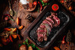 Juicy roasted veal tenderloin sliced decorated rosemary on dark board on dark wooden background in beautiful composition among vegetables and spices. Top view. Flat lay