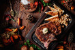 Juicy grilled steak T-Bone decorated rosemary on dark board with mushrooms and fried pita bread on dark wooden background in beautiful composition among vegetables and spices. Top view. Flat lay