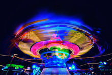 Bright Colorful Carosuell In Neon Colors In Motion At A Fun Fair During Evening.