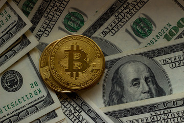 Wall Mural - Bitcoin on background of one hundred american dollars. Closeup top view