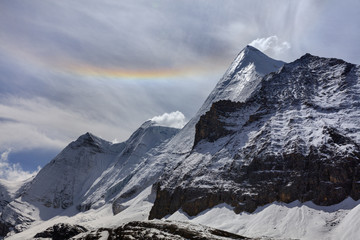 Wall Mural - Yangmaiyong, holy snow mountain in Daocheng Yading Nature Reserve - Garze, Kham Tibetan Pilgrimage region of Sichuan Province China. Rainbow in the sky above the summit of Jampayang