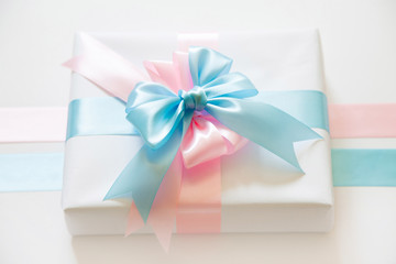 A gift for a boy and a girl at the same time. Surprise. Satin ribbon in blue and pink.