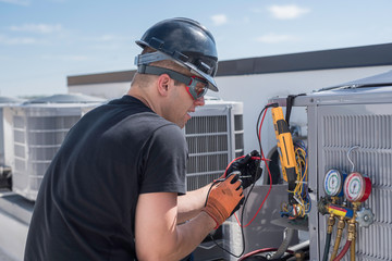 Hvac repair man working with tools on condenser