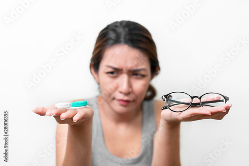Fotomural Asian woman holding glasses and contact lens on white background, Selective focus on glasses , myopia and eyesight problem concept