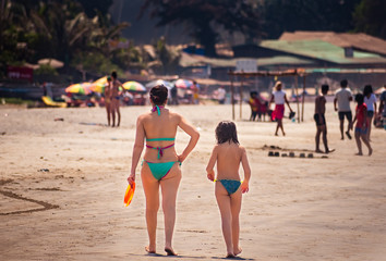 mother and daughter walking at the beach