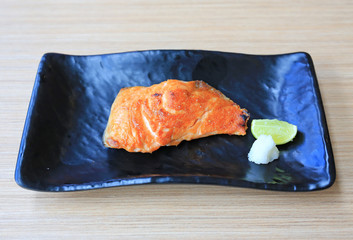 Canvas Print - Grilled Salmon fillet steak with salt served on black tray. Japanese cuisine.