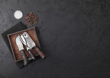 Vintage Meat Knife And Fork And Hatchet In Old Wooden Box On Black Table Background. Butcher Utensils. Space For Text