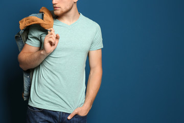 Wall Mural - Young man wearing blank t-shirt on blue background, closeup. Mockup for design