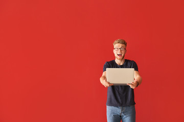 Sticker - Happy young man with laptop on color background