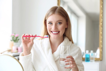 Wall Mural - Beautiful woman cleaning teeth at home