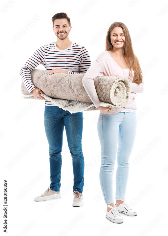 Young couple holding rolled carpet against white background