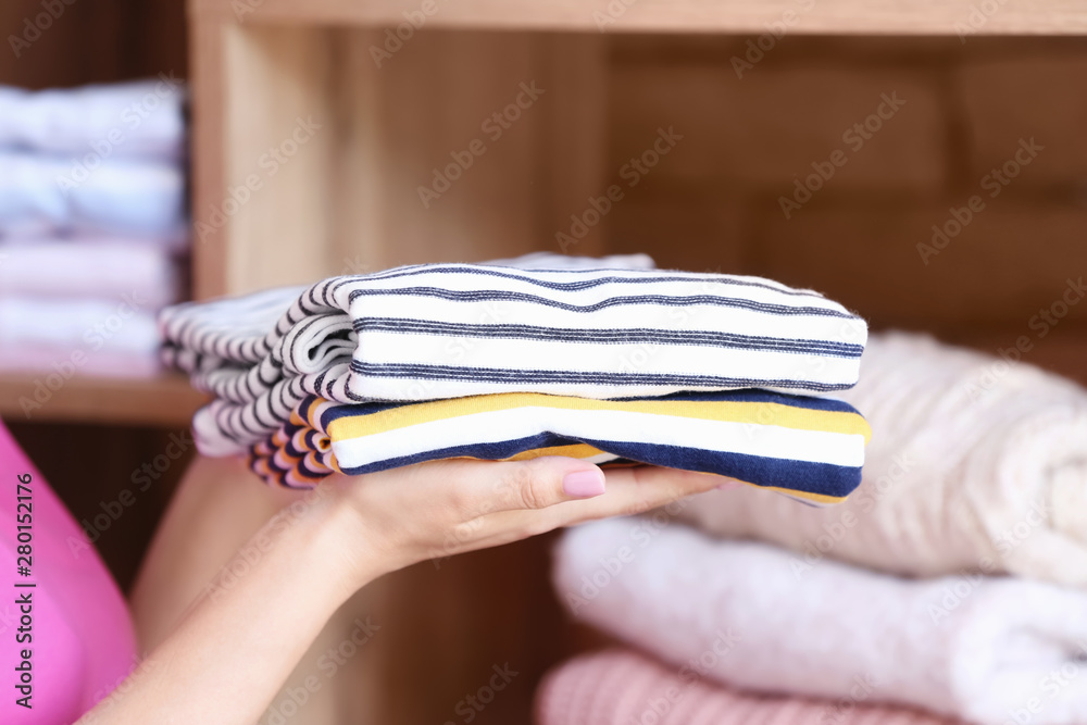 Woman with stack of clean clothes at home