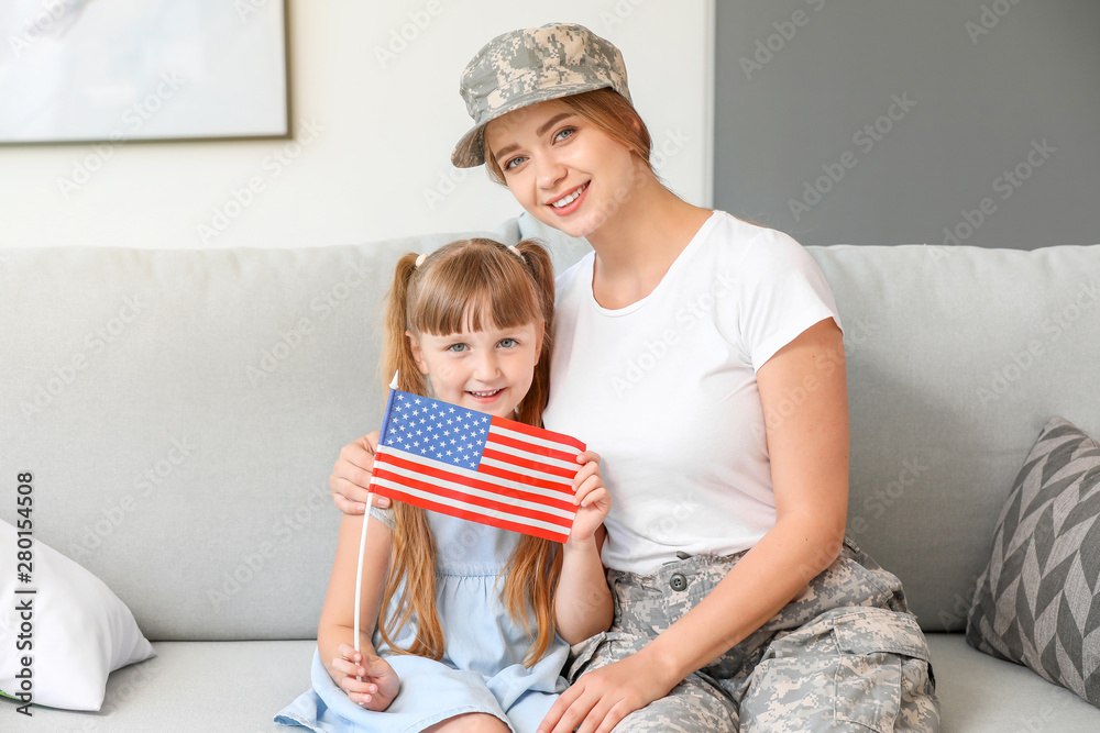 Happy female soldier with her daughter at home