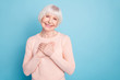 Portrait of positive woman putting her palm on chest smiling wearing pastel sweater isolated over blue background