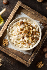 Wall Mural - Oatmeal with nuts (hazelnuts, walnuts) and honey, porridge for Breakfast. Tasty, healthy food