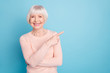 © deagreez - Portrait of lovely lady pointing at copy space having toothy smile isolated over blue background