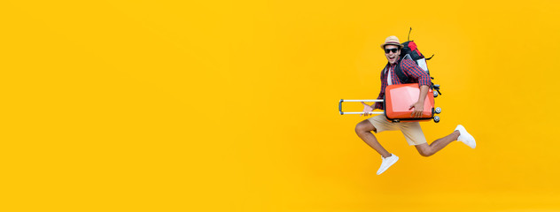 Handsome Indian tourist man with backpack holding baggage and jumping