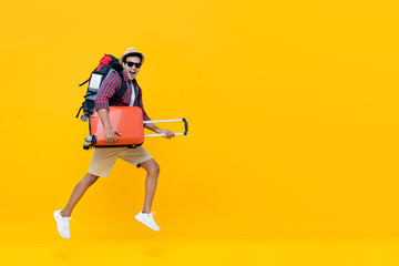 Wall Mural - Handsome Indian tourist man with backpack holding baggage and jumping