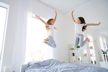 Sticker - Low angle photo of cute sweet kid blonde brunette jumping look raise hands feel content room indoors apartment