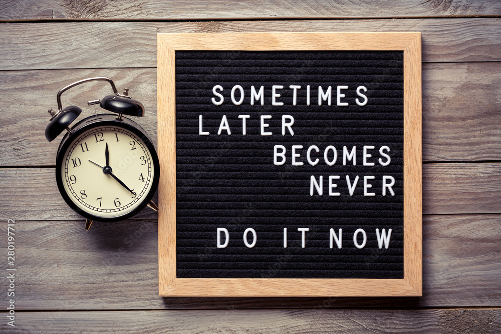 Inspirational motivational quote Sometimes later becomes never. Do it now words on a letter board on wooden background near vintage alarm clock. Success and motivation concept. - obrazy, fototapety, plakaty 