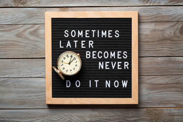 Inspirational motivational quote Sometimes later becomes never. Do it now words on a letter board on wooden background near vintage alarm clock. Success and motivation concept.