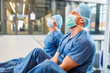 Zwei erschöpfte Chirurgen in blauer OP-Kleidung