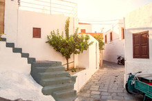 A Narrow Street With A Typical Greek House, Stairs And Motor Bikes. Beautiful Greek Architectures In Rhodes.