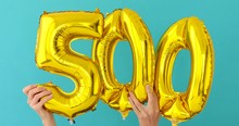 Gold Foil Number 500 Five Hundred Celebration Balloon On A Blue Background
