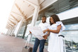 © Prostock-studio - Young black couple looking at map at airport terminal building