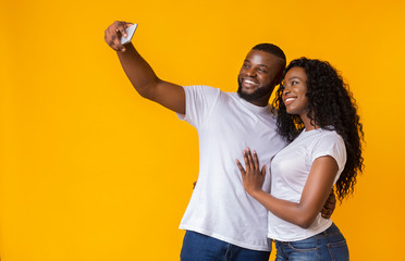 Wall Mural - Lovely black guy and girl are taking selfies