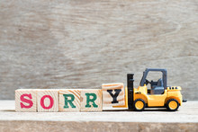 Toy Forklift Hold Letter Block Y To Complete Word Sorry On Wood Background