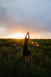 © bo.kvk - Woman enjoying nature in meadow. Outstretched arms fresh morning air summer Field at sunrise.