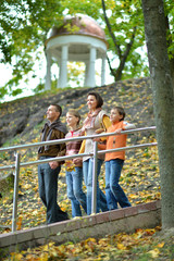 Wall Mural - Family of four walking in autumn park