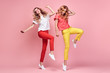 © evgenij918 - Two fashionable girl jump Smiling in colorful outfit on pink. Beautiful easy-going woman in red yellow pants, Stylish curly hair having fun. Joyful funny slim sisters friends, happy fashion concept