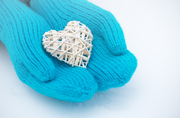 Female hands in mittens with heart, close-up