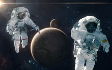 Two Astronauts On Background Of Earth And Moon. Solar System. Science Fiction. Elements Of This Image Furnished By NASA