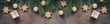 Christmas festive border, branch fir decorated with golden balls and stars, gift box, dark rustic background. Top view, flat lay.
