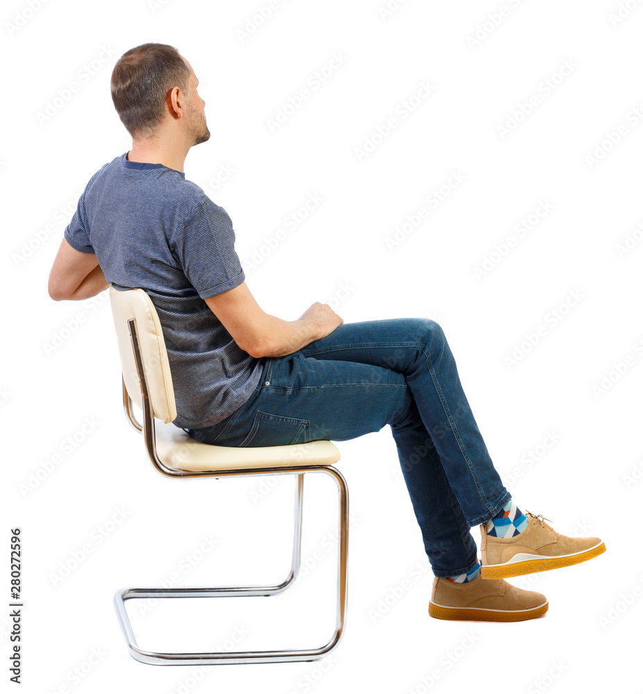 Side view of a man sitting on a chair. - obrazy, fototapety, plakaty 