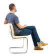canvas print picture - Side view of a man sitting on a chair.