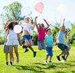 © JackF - Friendly kids with balloons jumping together in park on summer