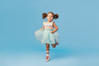 © oes - Little happy toddler child girl dreams of becoming ballerina in a cyan tutu skirt. Blue background. Space for text