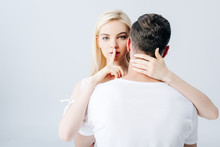 Beautiful Girl Embracing Man And Doing Silence Gesture Isolated On Grey